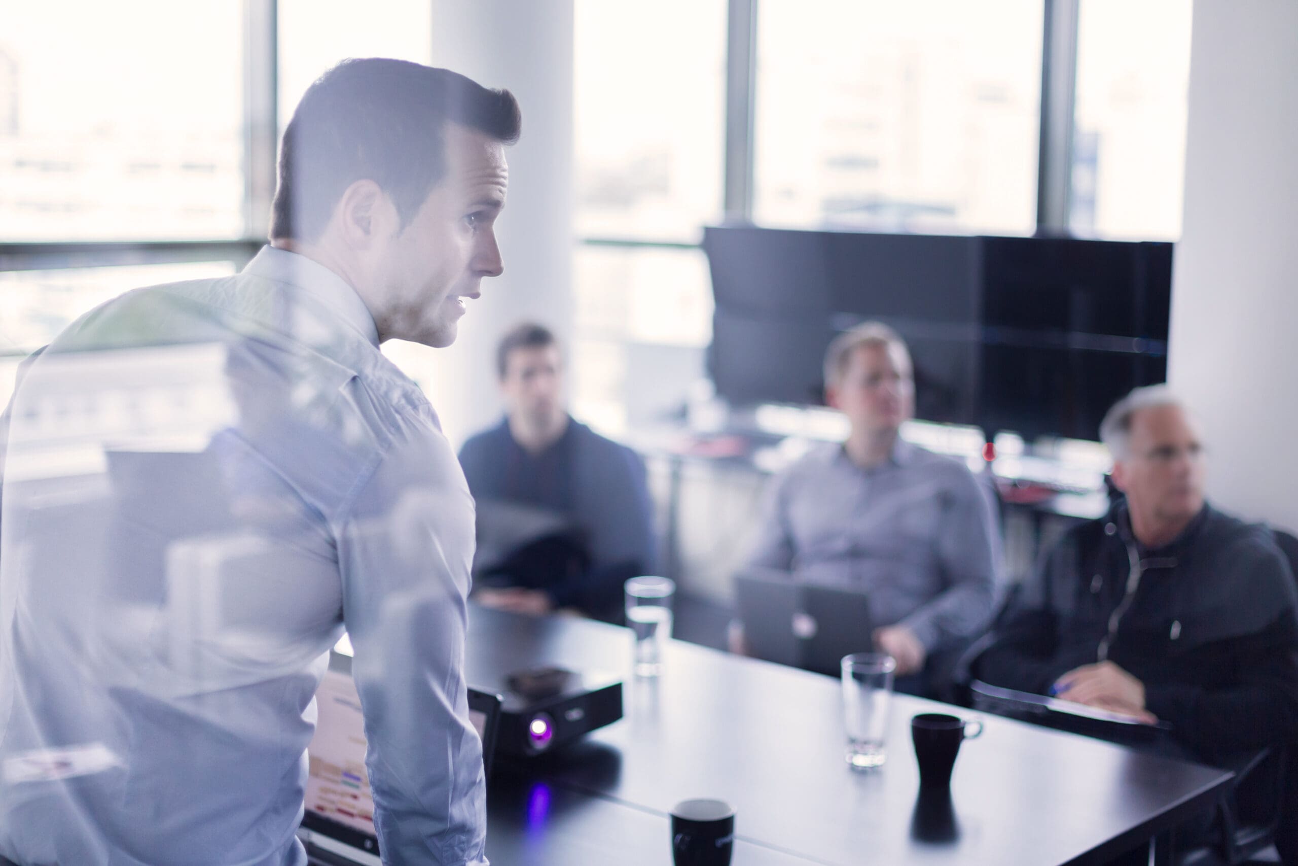 photo of men around a table during a presentation