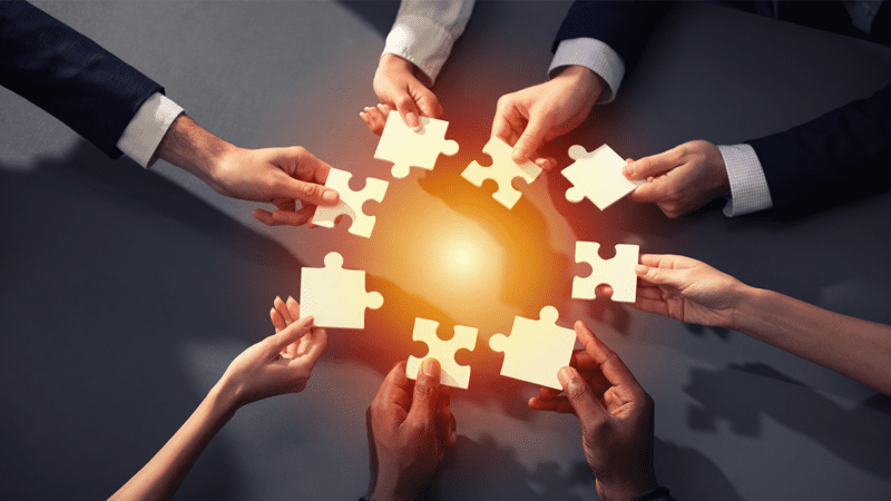 photo of people holding puzzle pieces together