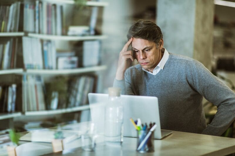 photo of man frowning at laptop