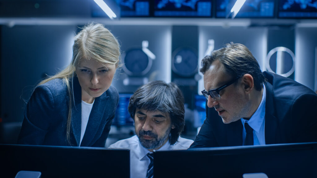 Groupe d'employés de bureau, hommes et femmes, travaillant sur des ordinateurs dans une salle de contrôle. Analystes d'une agence gouvernementale secrète effectuant des recherches dans le domaine de la cybersécurité.