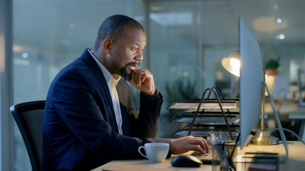 profile of man in suit working at an imac