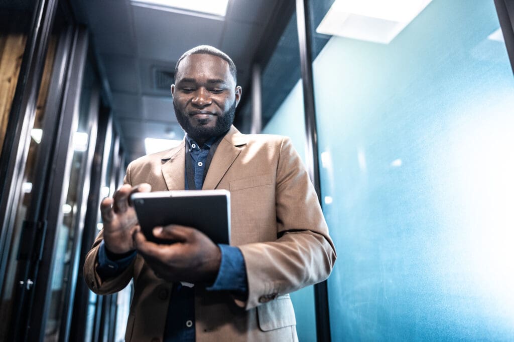 Business man using digital tablet in the office hallway