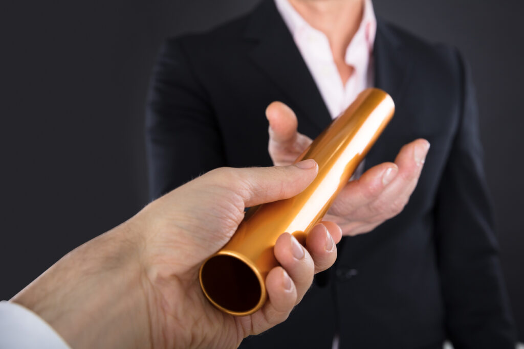 Business continuity, man passing a Golden Relay baton
