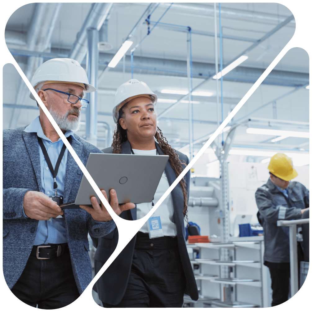 2 people walking through a manufacturing plant on a laptop